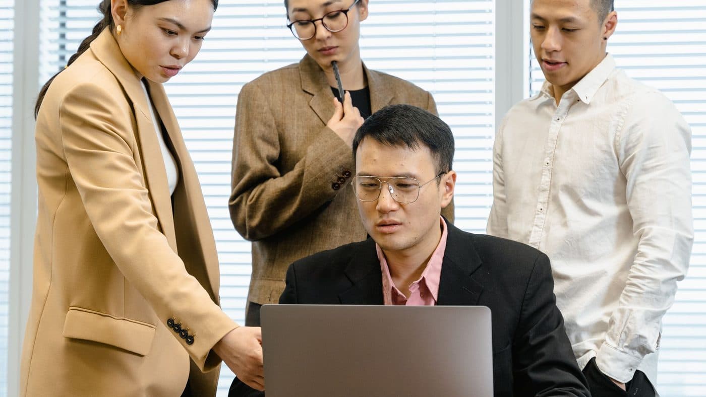 Deux collaborateurs consultant ensemble un tableau de bord logiciel sur un écran d'ordinateur.