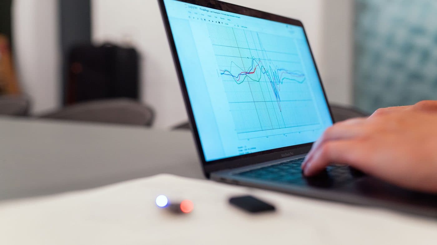 Une personne analysant des graphiques de données sur l'écran d'un ordinateur portable.