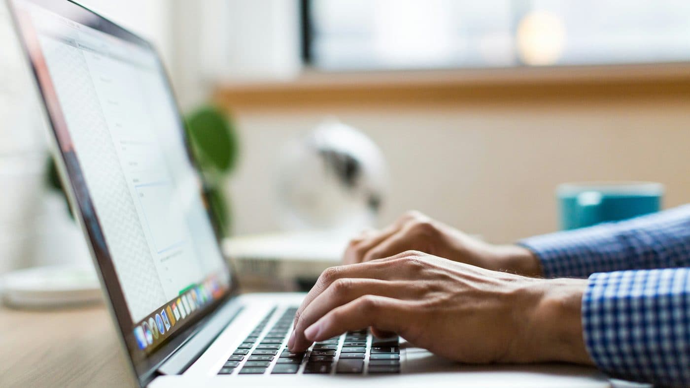Personne tapant sur un ordinateur portable, gros plan sur les mains et le clavier