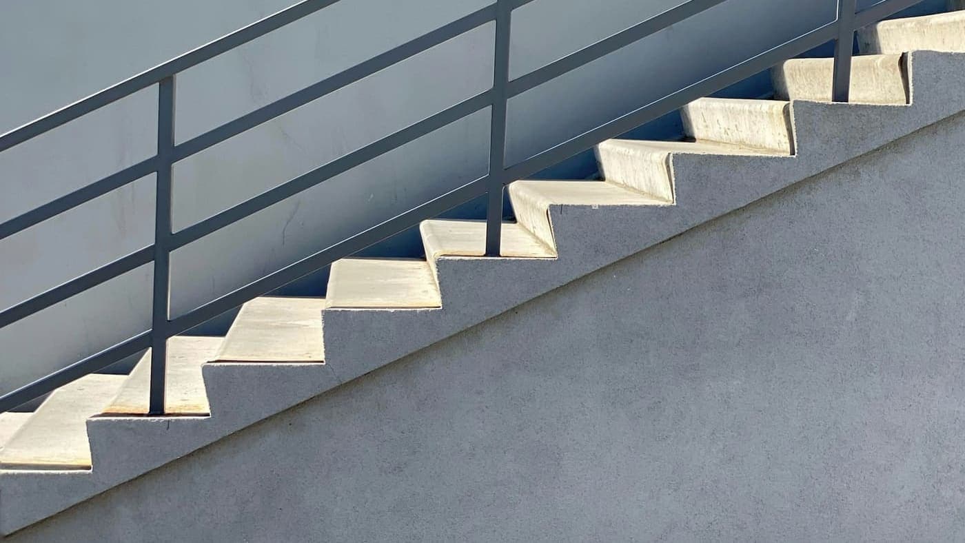 Escalier en béton clair vu de côté, marche après marche