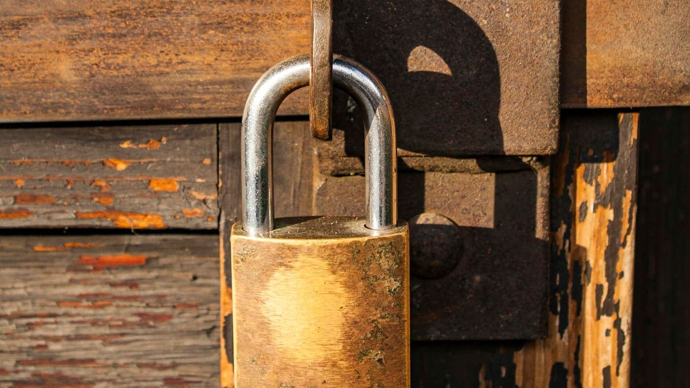 Cadenas en laiton fermé sur une porte en bois